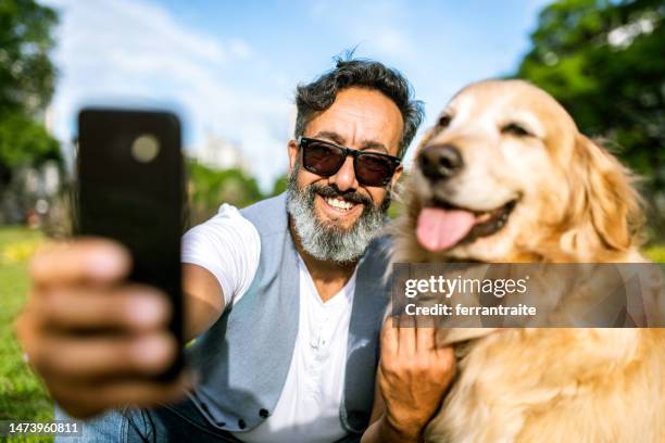 mature man taking a selfie with golden retriever - animal selfies stock pictures, royalty-free photos & images