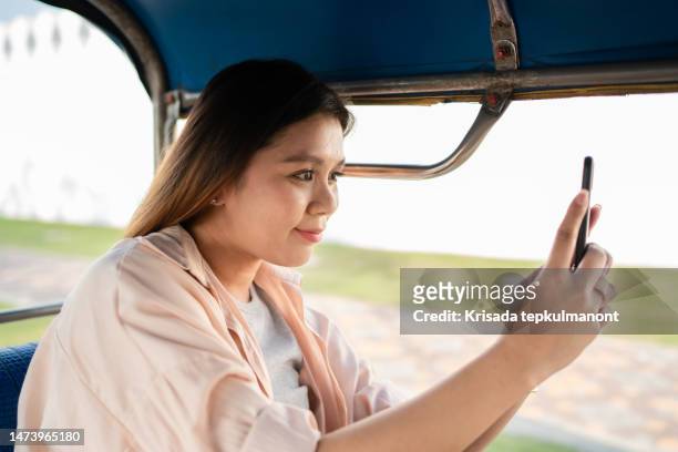 young asian woman taking tuk-tuk on tour to beautiful temple. - active lifestyle icons stock pictures, royalty-free photos & images