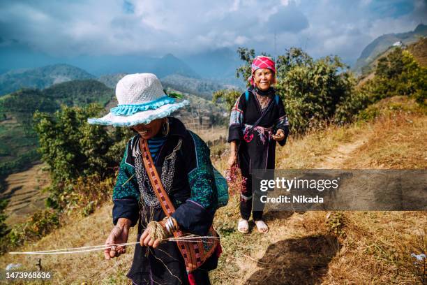 two women from black hmong tribe hiking in the mountains near sapa, north vietnam - sa pa imagens e fotografias de stock