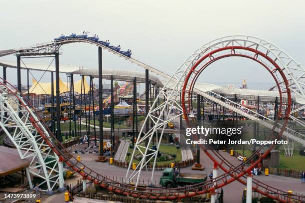 Aerial view of visitors riding on a roller coaster and other attractions at Blackpool Pleasure Beach amusement park in the seaside resort town of...