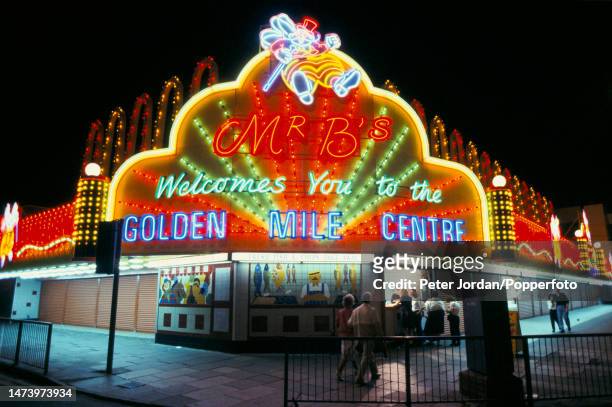 Visitors queue to buy fish and chips from Mr B's neon lit takeaway on the Promenade and Golden Mile in the seaside resort town of Blackpool in...