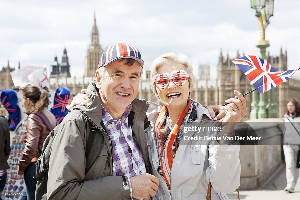 Mature couple wearing tourist glasses and hat.