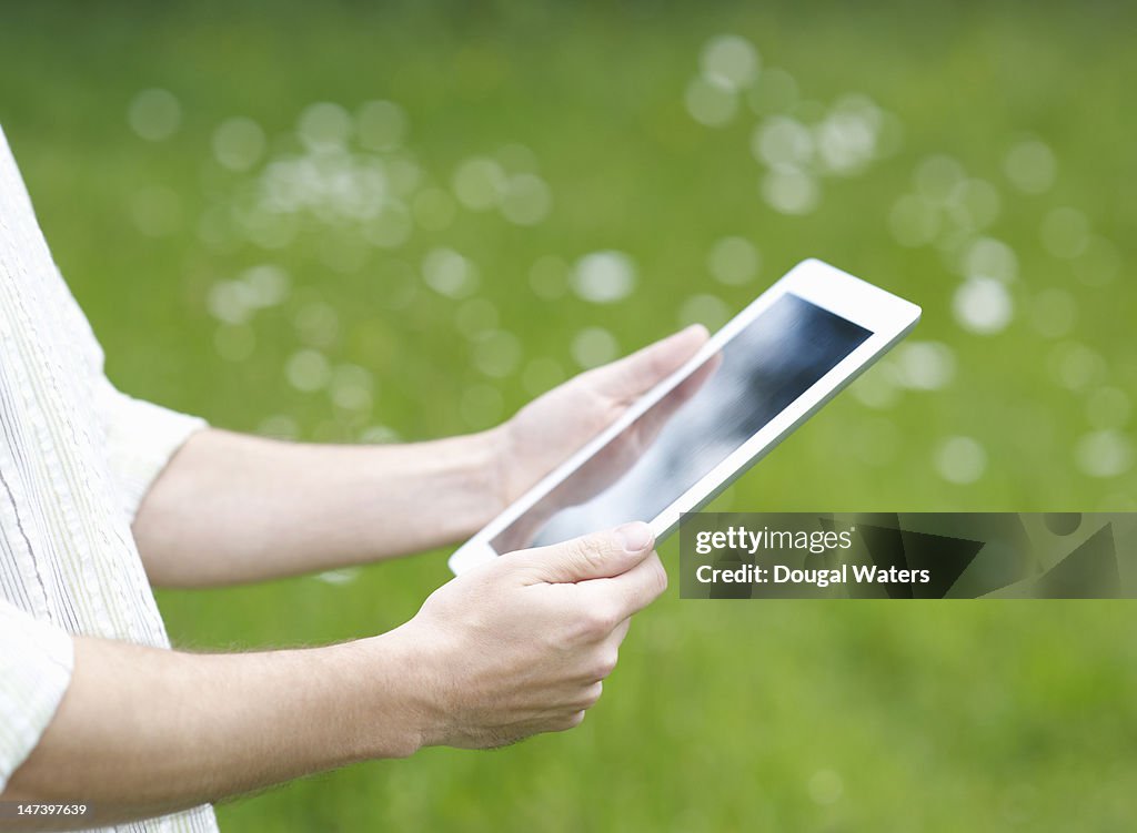 Man holding a digital tablet in the countryside