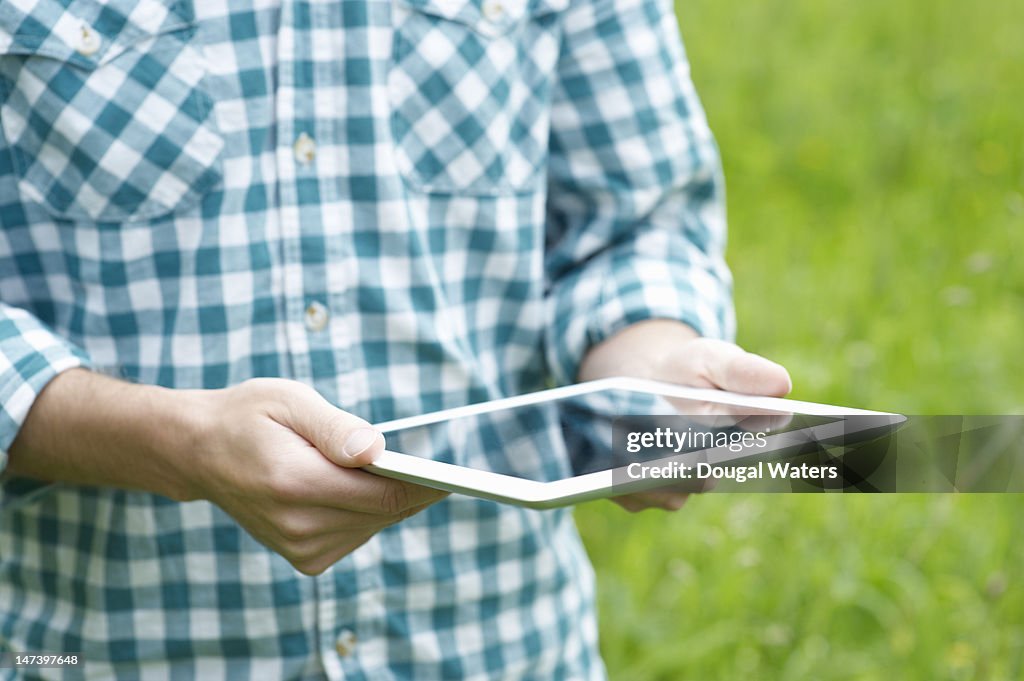 Man in the countryside using a digital tablet