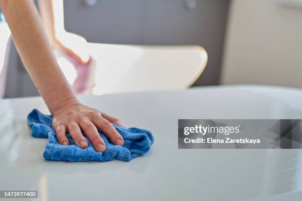 close-up of a hand wiping a table with a rag - vod stockfoto's en -beelden