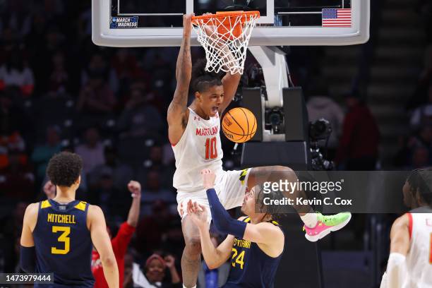 Julian Reese of the Maryland Terrapins dunks the ball against Patrick Suemnick of the West Virginia Mountaineers during the second half in the first...