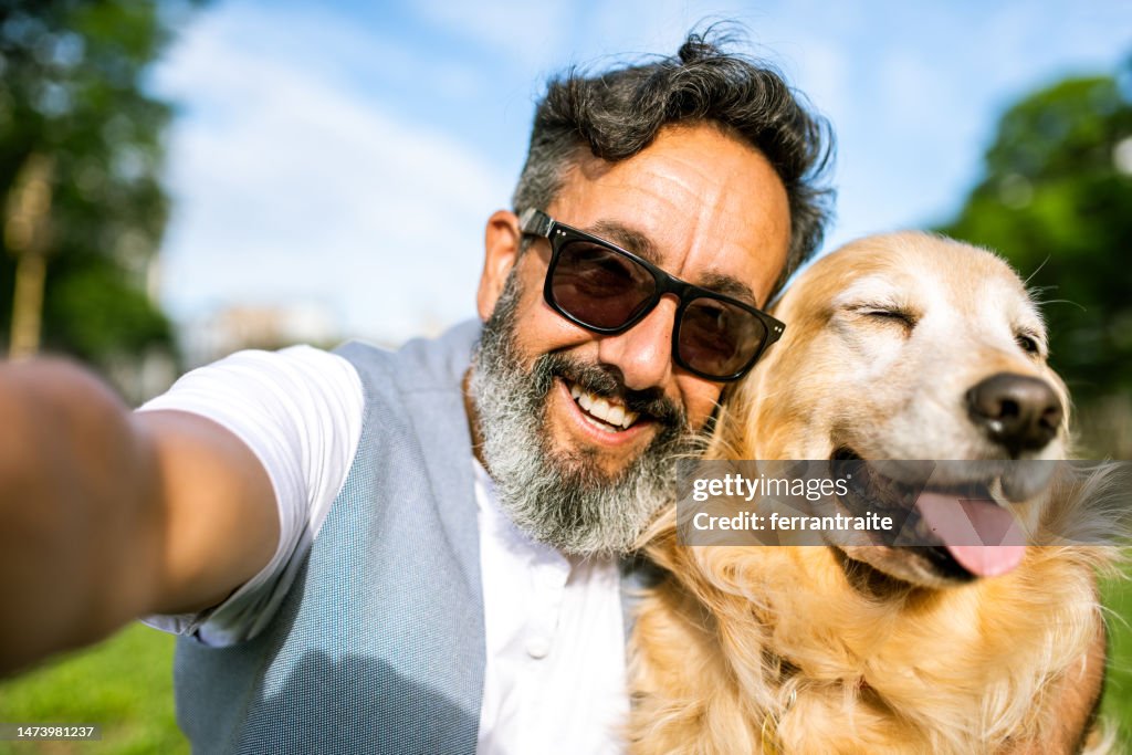 Mature man taking a selfie with golden retriever