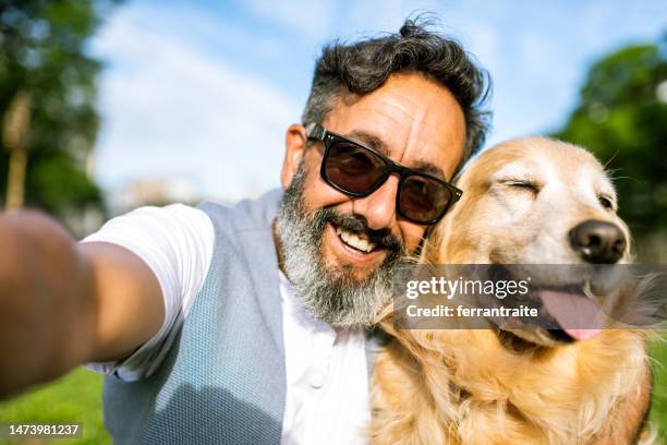 mature man taking a selfie with golden retriever - mature adult walking dog stock pictures, royalty-free photos & images