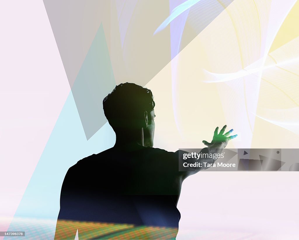 Man reaching out to futuristic colourful light