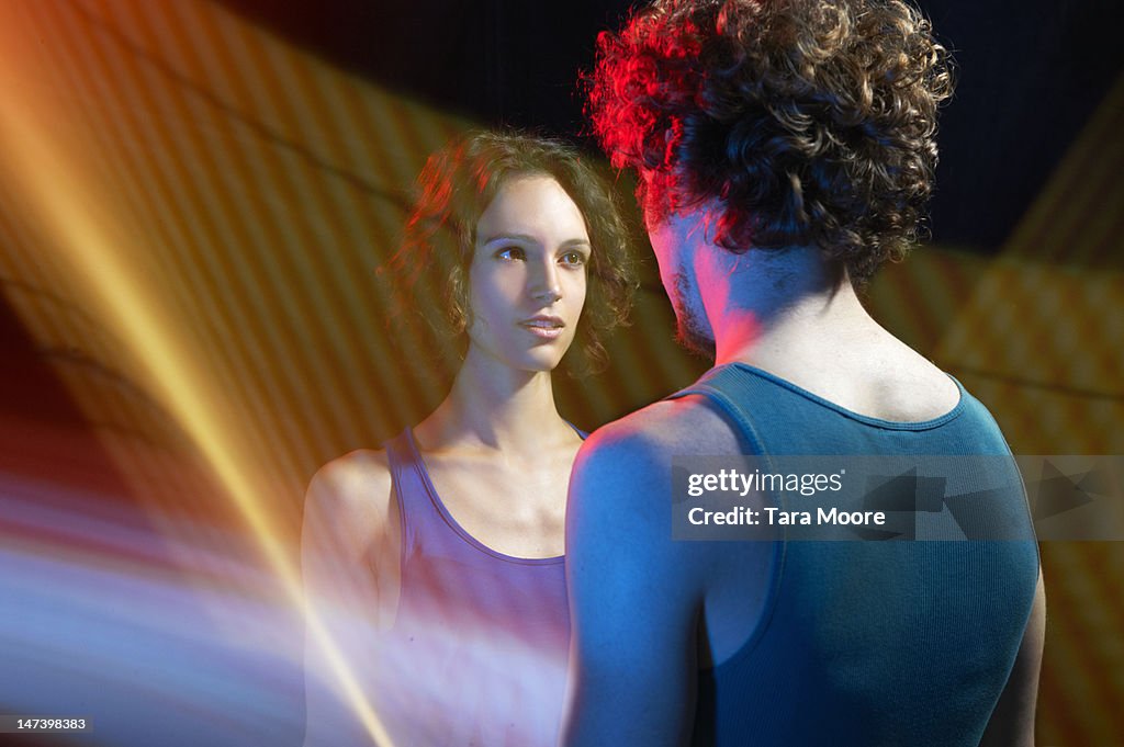 Woman looking at man through light trails