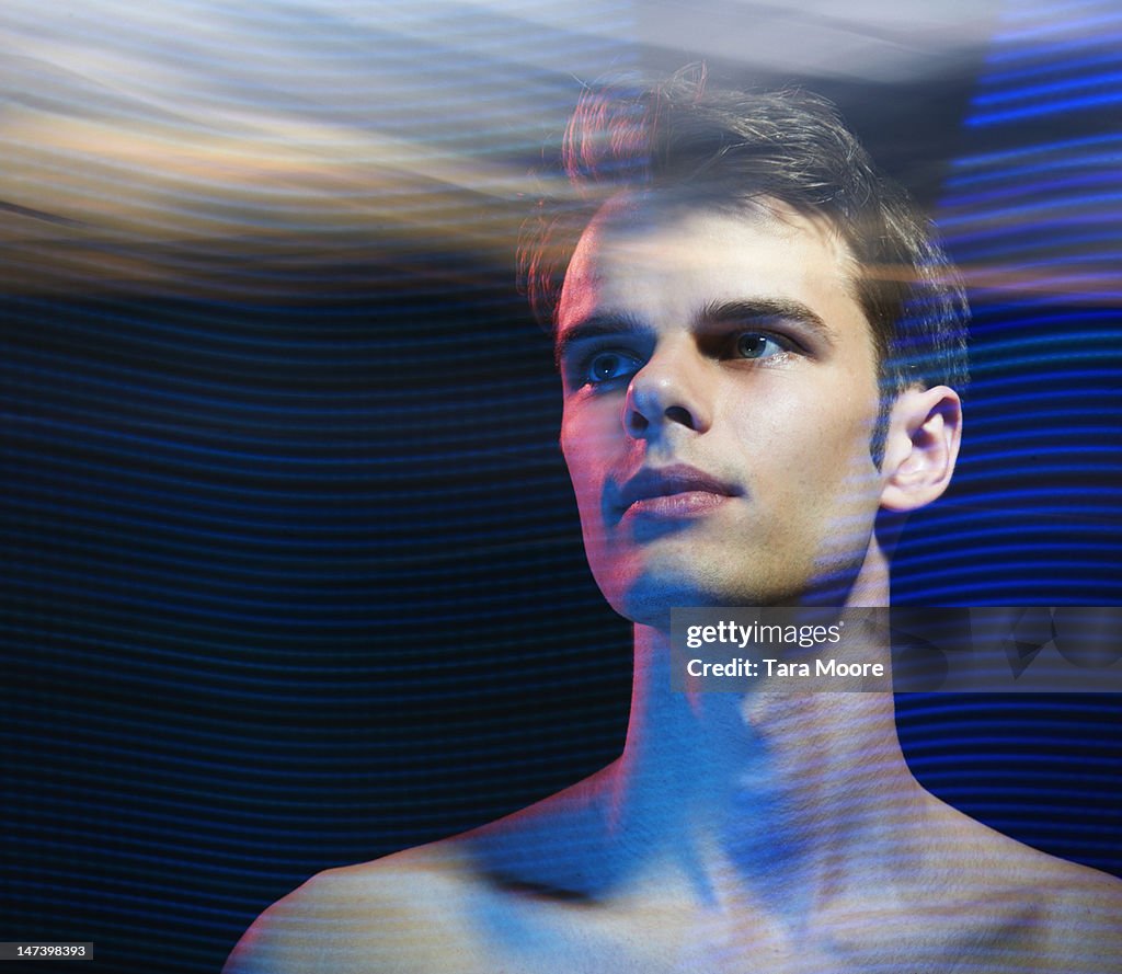 Portrait of man looking at futuristic light trails