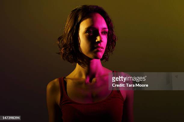 portrait of woman with yellow and pink light - color image stock-fotos und bilder