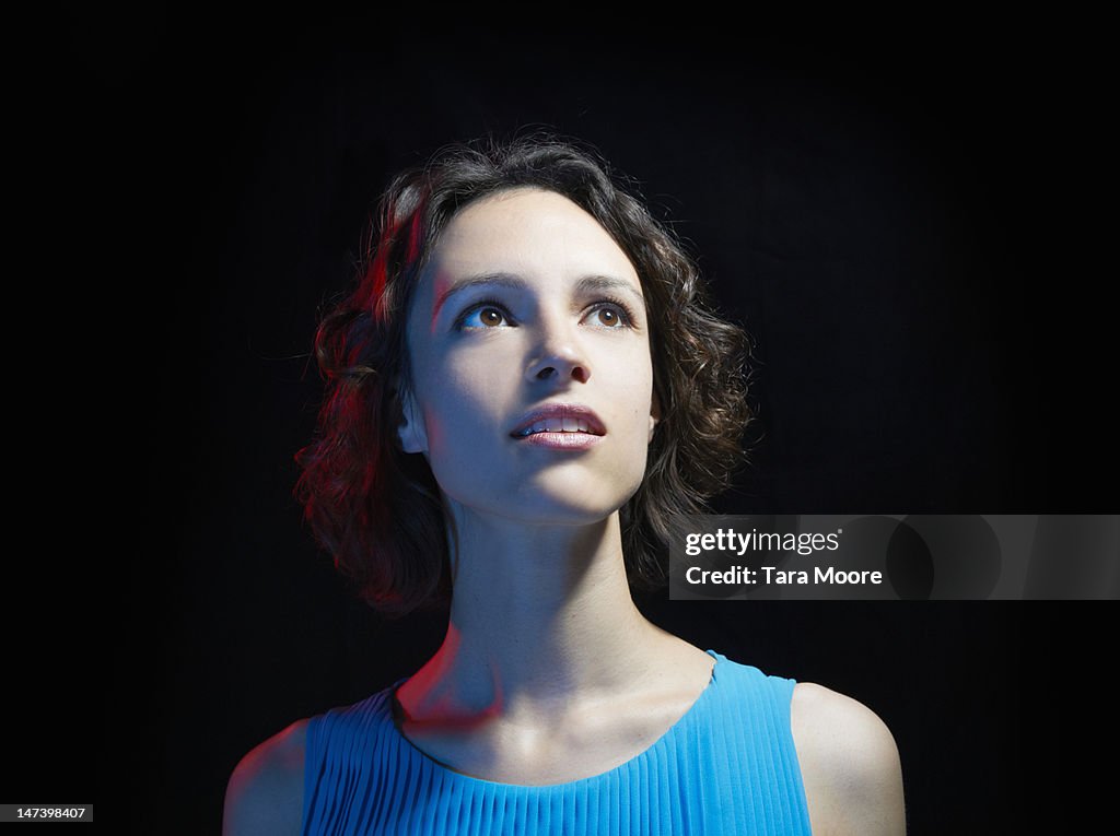 Woman looking up with black background