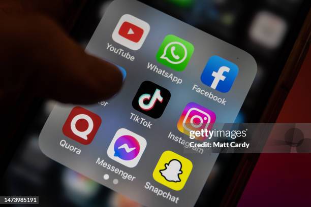 In this photo illustration the logo of Chinese online social media and video hosting service TikTok is displayed on a smartphone screen alongside...