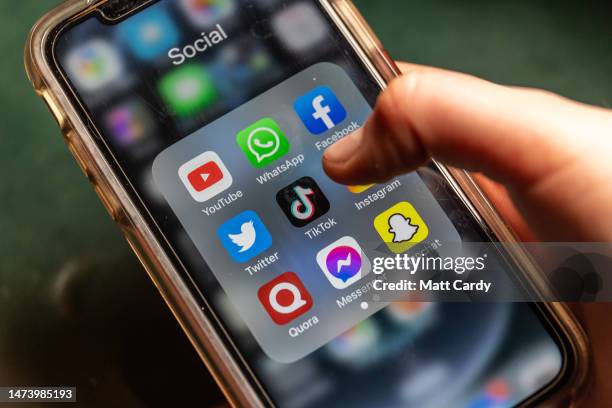 In this photo illustration the logo of Chinese online social media and video hosting service TikTok is displayed on a smartphone screen alongside...