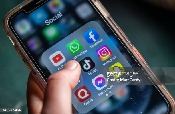 In this photo illustration the logo of Chinese online social media and video hosting service TikTok is displayed on a smartphone screen alongside...