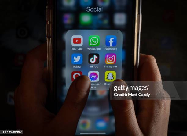 In this photo illustration the logo of Chinese online social media and video hosting service TikTok is displayed on a smartphone screen alongside...