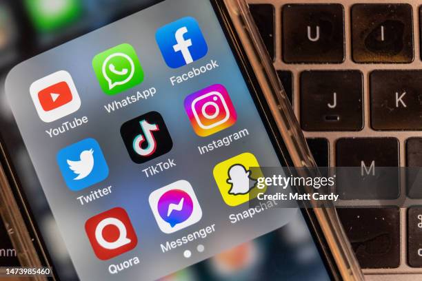 In this photo illustration the logo of Chinese online social media and video hosting service TikTok is displayed on a smartphone screen alongside...