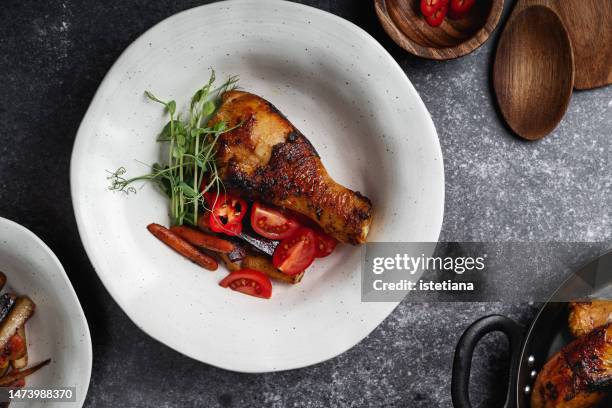 roasted chicken curry leg with roasted carrot and tomato salad in bowl, directly above - cultivated meat stock pictures, royalty-free photos & images