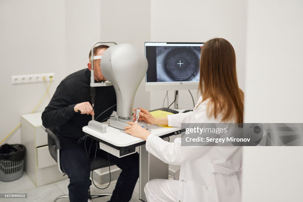 Optometrist examining patient at clinic