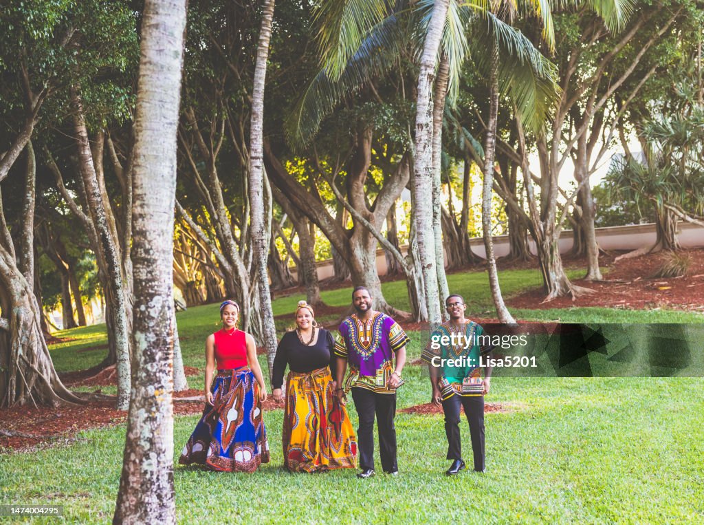 Family in traditional Kwanzaa style clothing in a candid family portrait outdoors