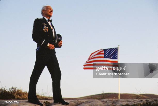 Astronaut Buzz Aldrin poses for a portrait in his Air Force uniform with the American Flag flying behind him circa 1990 in Los Angeles, California