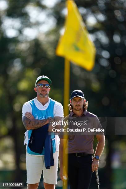 Caddie Ian Finnis and Tommy Fleetwood of England stand on the 13th green during the first round of the Valspar Championship at Innisbrook Resort and...