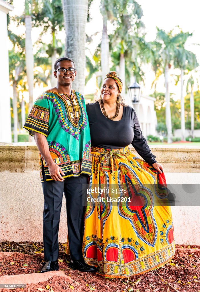 Mother and adult son dressed in dashiki and traditional clothing to celebrate Kwanzaa in outdoor happy family portrait