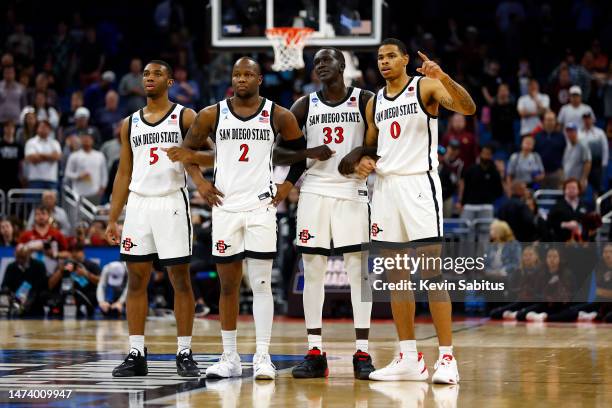 Lamont Butler, Adam Seiko, Aguek Arop and Keshad Johnson of the San Diego State Aztecs celebrate after defeating the the Charleston Cougars 63-57 in...