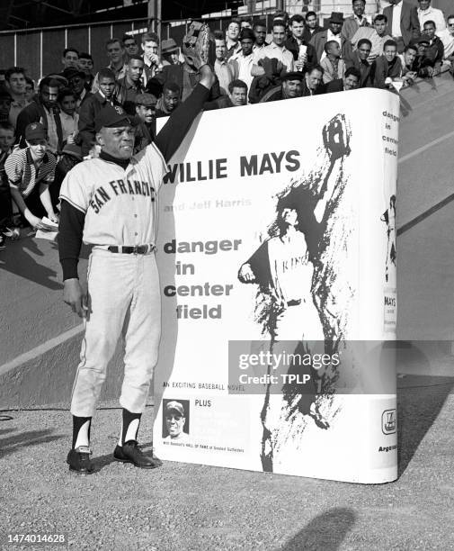 Willie Mays of the San Francisco Giants stands next to his book "Willie Mays: Danger in Center Field" poster prior to an MLB game against the New...