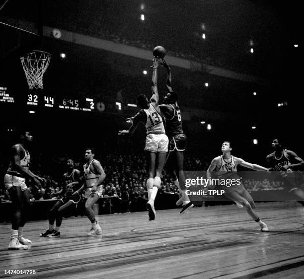 Bill Russell of the Boston Celtics takes the hook shot over Wilt Chamberlain of the Philadelphia Warriors as Woody Sauldsberry, Guy Rodgers and Tom...