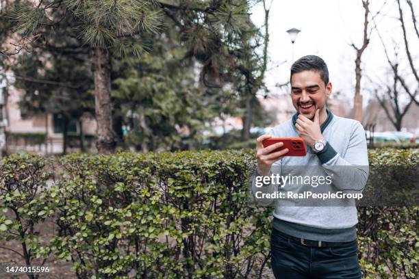 man standing in the park and watching a stream - streaming media service stock pictures, royalty-free photos & images