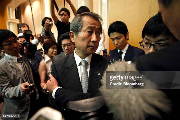Kenichi Watanabe, president and chief executive officer of Nomura Holdings Inc., center, leaves after a news conference at the company's headquarters...
