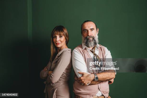 portrait of a mature adult couple against a green wall - business mature couple portrait bildbanksfoton och bilder