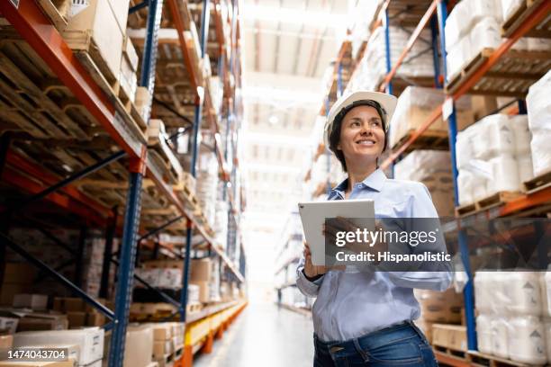woman supervising the operation of a distribution warehouse - southern european descent stock pictures, royalty-free photos & images