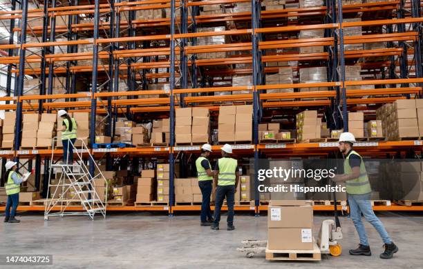 group of employees working at a distribution warehouse - pallet jack stock pictures, royalty-free photos & images