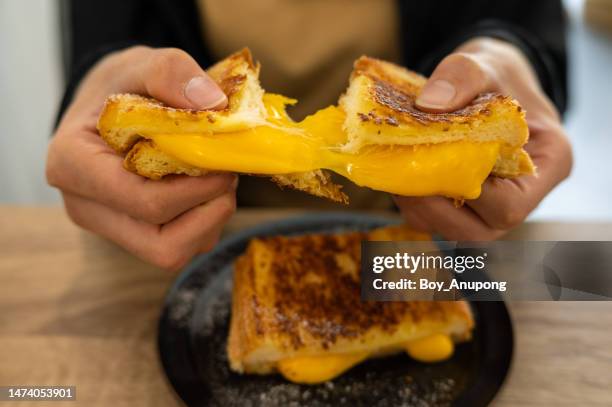someone holding a cheese toast before eating. - boterham met kaas stockfoto's en -beelden
