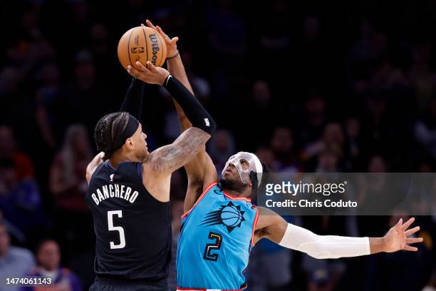 Josh Okogie of the Phoenix Suns blocks a shot by Paolo Banchero of the Orlando Magic during the second half at Footprint Center on March 16, 2023 in...