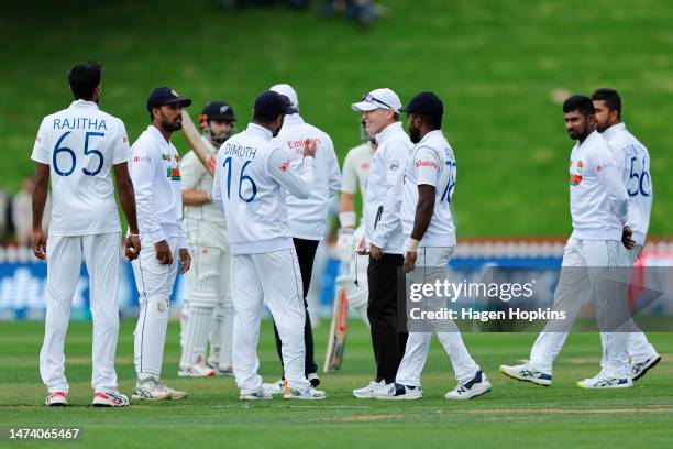 Dimuth Karunaratne of Sri Lanka speaks to Umpire Chris Gaffaney as poor light delays play during day one of the Second Test Match between New Zealand...