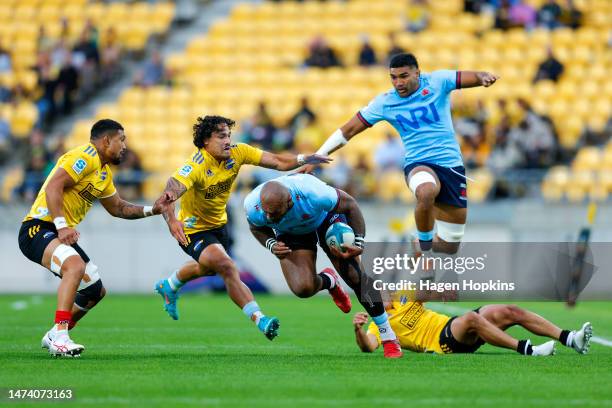 Nemani Nadolo of the Waratahs is tackled by Billy Proctor and Ardie Savea of the Hurricanes during the round four Super Rugby Pacific match between...