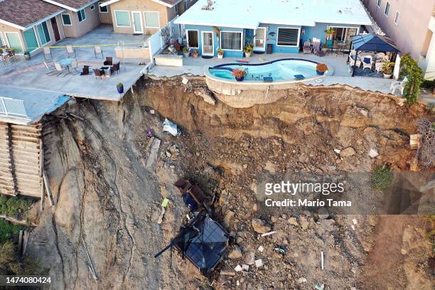 An aerial view of a remaining pool at the edge of a hillside landslide brought on by heavy rains, which caused four ocean view apartment buildings to...