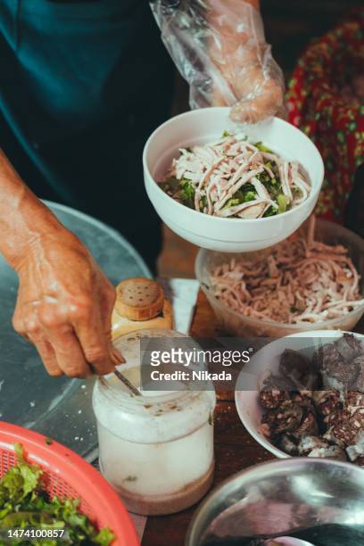 senior woman preparing pho soup at market in bac ha, vietnam - vietnamese ethnicity stock pictures, royalty-free photos & images