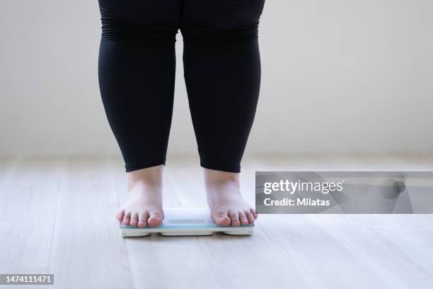 a woman's feet on a weight scale - obesity imagens e fotografias de stock