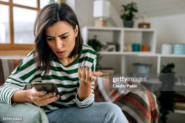 worried young woman using mobile phone - female worried mobile imagens e fotografias de stock