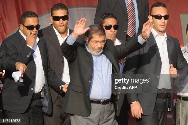 Flanked by bodyguards, Egypt's Islamist president-elect Mohamed Morsi salutes tens of thousands of Egyptians he addressed in Cairo's iconic Tahrir...