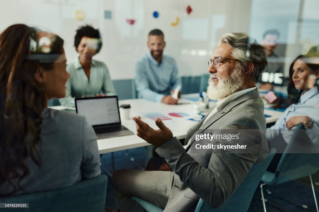 Senior businessman talking to his colleague on a meeting in the office.