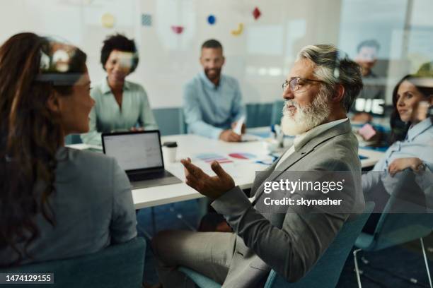 empresário sênior conversando com seu colega em uma reunião no escritório. - grupo grande de pessoas - fotografias e filmes do acervo