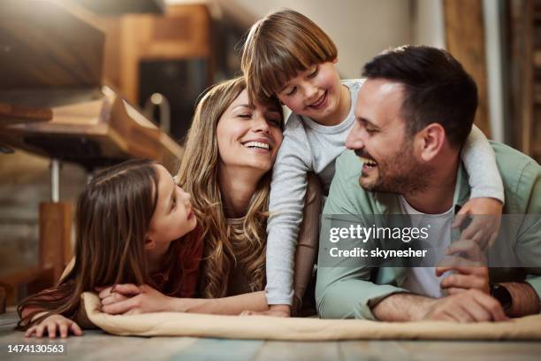 familia joven y feliz hablando en manta en casa. - familia fotografías e imágenes de stock