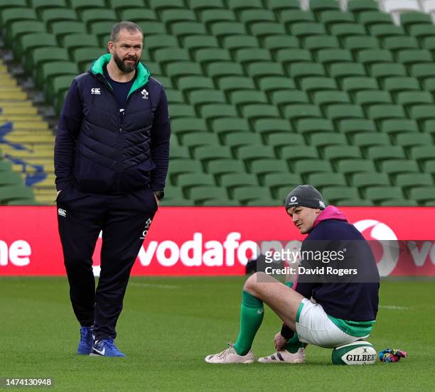 Johnny Sexton the Ireland captain looks on with head coach Andy Farrell during the Ireland captain's run at the Aviva Stadium on March 17, 2023 in...