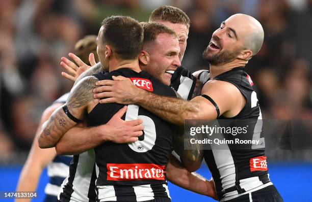 Tom Mitchell of the Magpies is congratulated by team mates after kicking a goal during the round one AFL match between Geelong Cats and Collingwood...